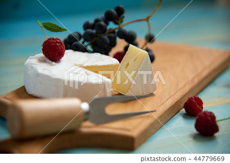 cheese camembert with raspberries and grapes on 44779669