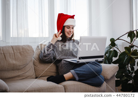 Woman showing victory gesture during video call 44780172