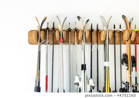 Lot of ski hanged on customized wooden wall mount at garage for seasonal storage. Extreme winter 44781168