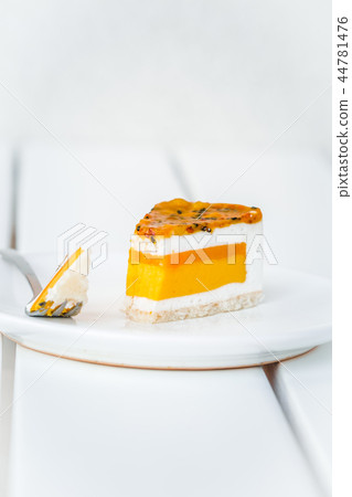 Slice of mango passion fruit coconut cake on white Slice of mango passion fruit coconut cake on white 44781476
