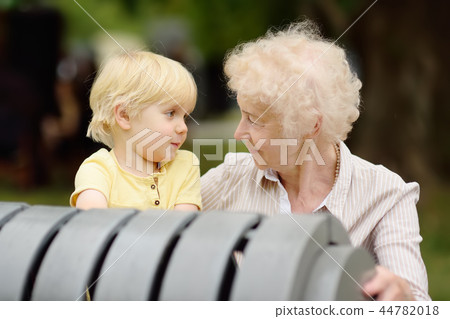 Beautiful granny and her little grandchild together in park Beautiful granny and her little grandchild together in park 44782018