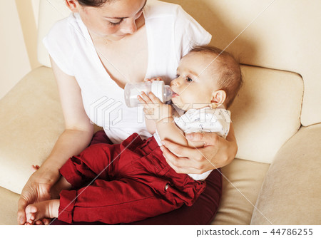 young brunette happy mother holding toddler baby son, breast-fee 44786255
