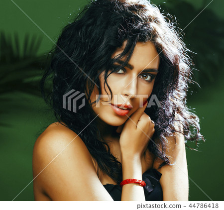 young pretty brunette woman on green background smiling happy, l 44786418