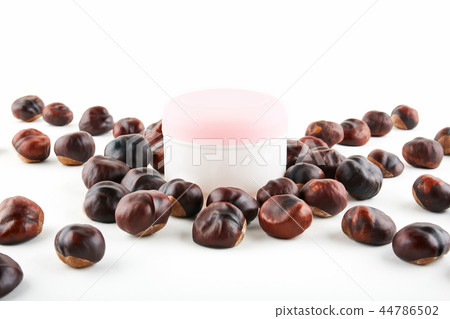Cosmetic jar and chestnuts on white background Cosmetic jar and chestnuts on white background 44786502