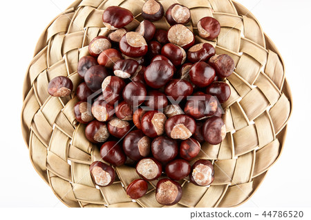 Wicker hat filled with chestnuts. 44786520