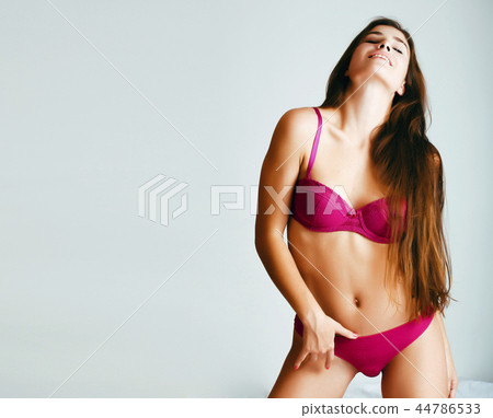 young pretty female in pink underwear in her bed smiling confide young pretty female in pink underwear in her bed smiling confide 44786533