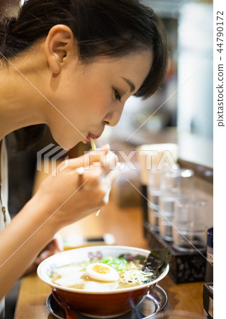 A woman who enjoys ramen alone 44790172