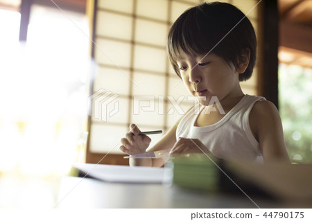 Boy doing homework on summer vacation Boy doing homework on summer vacation 44790175