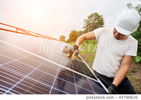 Installation of stand-alone exterior photo voltaic panels system. Renewable green energy generation. 44790626