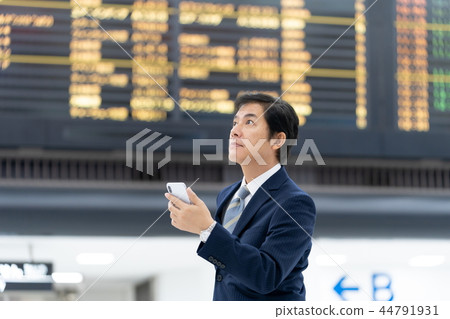 Businessman checking in front of airport billboard Businessman checking in front of airport billboard 44791931
