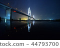 Suspension bridge at night reflected in the water 44793700