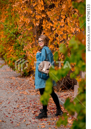 girl in glasses and jacket in a autumn season park. girl in glasses and jacket in a autumn season park. 44796133