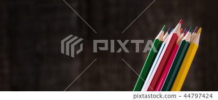 Colour pencils in holder on wooden background 44797424
