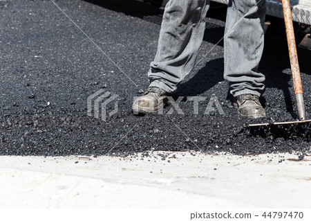 Worker navigating pavement truck 44797470