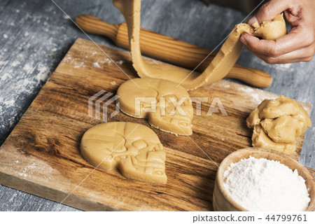 man preparing skull-shaped cookies 44799761