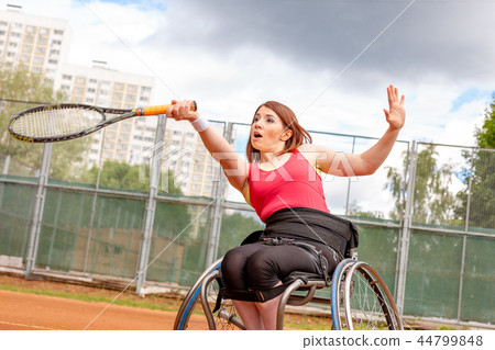 Disabled young woman on wheelchair playing tennis on tennis court. 44799848