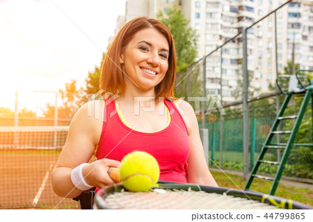 Disabled young woman on wheelchair playing tennis on tennis court. Disabled young woman on wheelchair playing tennis on tennis court. 44799865