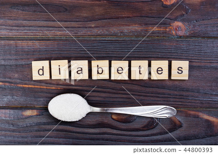 Diabetes wooden letters and sugar pile on a spoon Diabetes wooden letters and sugar pile on a spoon 44800393