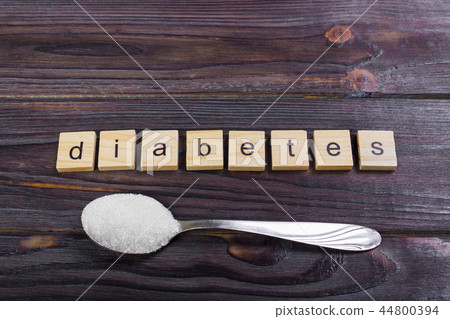 sugar pile on a spoon and diabetes wooden letters 44800394