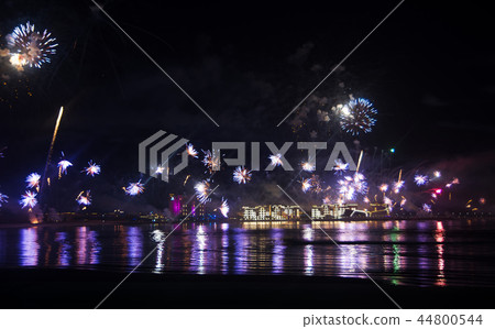 Festive firework over seaside water 44800544