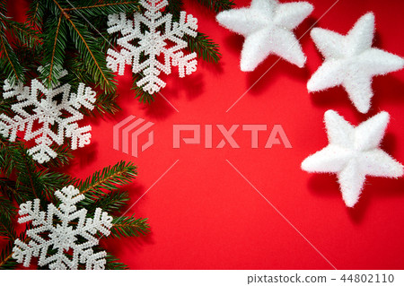 christmas white stars on a red background with twigs of spruce 44802110