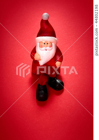 santa claus figurine on a red background 44802198