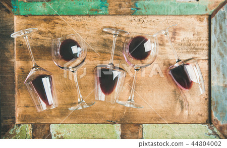 Red wine in glasses over rustic wooden tray background Red wine in glasses over rustic wooden tray background 44804002
