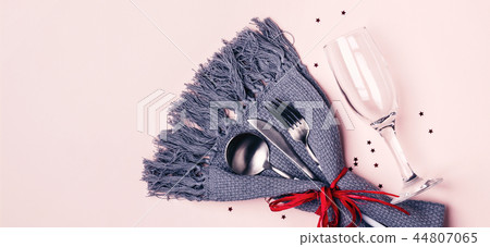 Champagne glass, cutlery and napkin on pink pastel background. Long banner format 44807065
