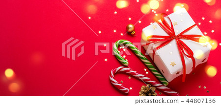 Christmas gift box and candy cane with shining lights. Long banner format 44807136