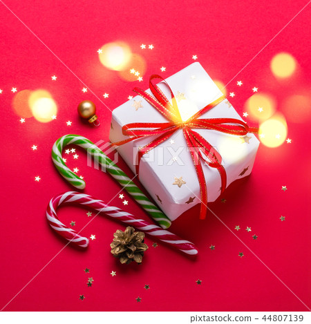 Christmas gift box and candy cane with shining lights Christmas gift box and candy cane with shining lights 44807139