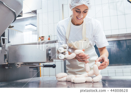Woman making sausages in butchery  44808628