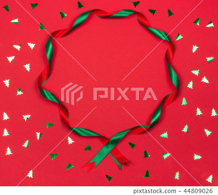 Christmas wavy ribbon round frame on red background. 44809026