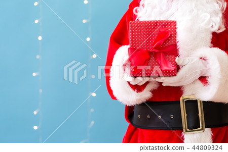 Santa holding a Christmas gift 44809324