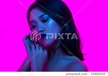 High Fashion model woman in colorful bright lights posing in studio High Fashion model woman in colorful bright lights posing in studio 44809450