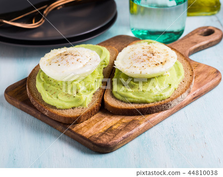 Rye bread avocado toasts with poached egg 44810038