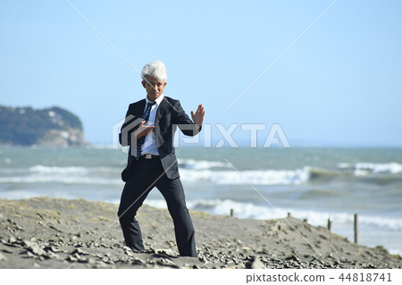 Romance gray businessman hitting karate type on sandy beach Romance gray businessman hitting karate type on sandy beach 44818741