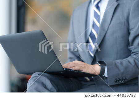 Business man operating a computer at the airport Business man operating a computer at the airport 44819788