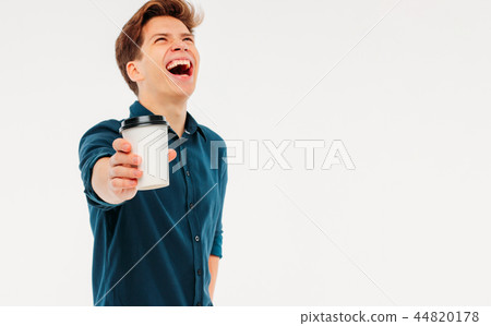 Attractive happy young man holding cup of coffee Attractive happy young man holding cup of coffee 44820178