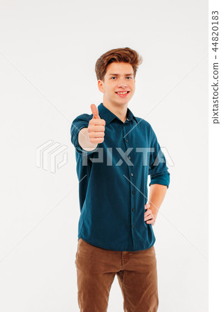 Attractive smiling boy student showing thumbs up Attractive smiling boy student showing thumbs up 44820183