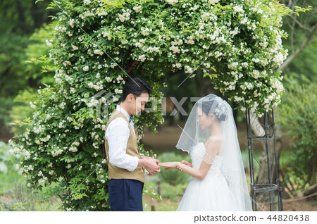 一男一女在花園婚禮上交換戒指 44820438