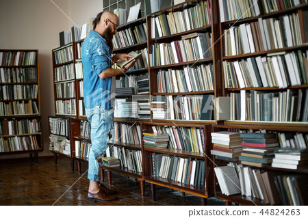 Full length portrait of stylish bearded man reading book Full length portrait of stylish bearded man reading book 44824263