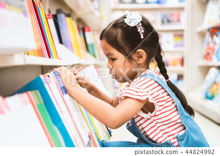asian girl select book on bookshelf in bookstore asian girl select book on bookshelf in bookstore 44824992