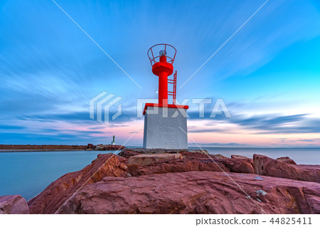 Marina mouth entrance with lighthouse at dusk 44825411