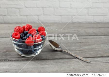 Small glass bowl full of blueberries  raspberries 44826765