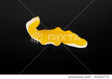 jelly candies in the crocodile shape on a black background. 44826773