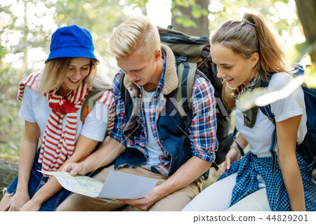 Group of friends watching the route in the traveler map on hiking Group of friends watching the route in the traveler map on hiking 44829201