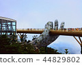 A bridge supported by a huge hand of God 44829802