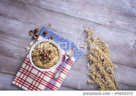 Oatmeal in a plate. Napkin. Nuts Berries. Honey Oatmeal in a plate. Napkin. Nuts Berries. Honey 44830255