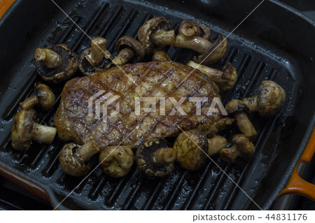 Cooking steak and mushrooms on the grill pan Cooking steak and mushrooms on the grill pan 44831176