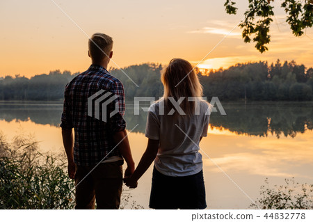 Couple holding hands at sunset 44832778